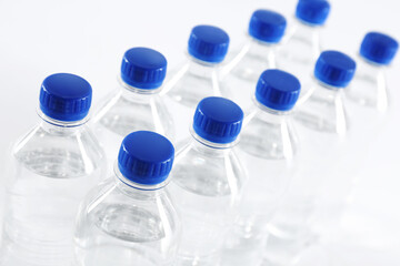 Plastic bottles with pure water on white background, closeup