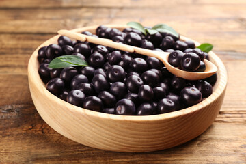Fresh acai berries in plate on wooden table