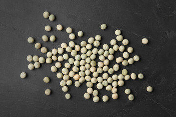Raw dry peas on black background, flat lay. Vegetable seeds