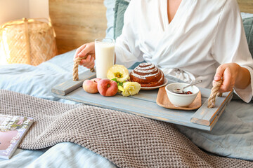Obraz na płótnie Canvas Young woman having tasty breakfast in bed