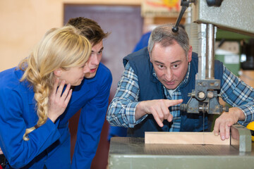 woman as apprentice or trainee beeing tested by craftsman