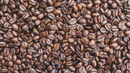 Brown roasted whole coffee beans background. Dark roast for your brewing method. Seed nature from above view. Group agriculture grain arabica. Photos from the top view. Top-down