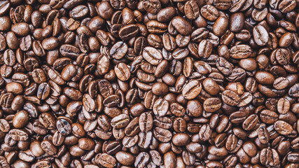 Brown roasted whole coffee beans background. Dark roast for your brewing method. Seed nature from above view. Group agriculture grain arabica. Photos from the top view. Top-down