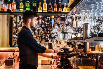 Close-up of barista making espresso from a coffee machine in a restaurant, bar or pub. Professional coffee brewing. Latte art with espresso machine steam in cafe. Vintage color tone