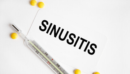 Obraz premium The inscription on the SINUSITIS business card, next to it are neatly white tablets.