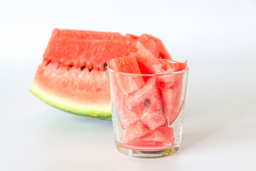 Red ripe watermelon, sliced on a white background. Watermelon slices in a glass.