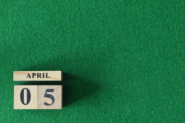 April 5, number cube on snooker table, sport background.