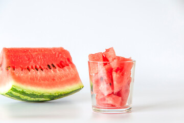 Red ripe watermelon, sliced on a white background. Watermelon slices in a glass.