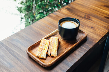 Grilled cheese sandwich with hot latte on wooden table in cafe. Cup of coffee the best start to any morning.