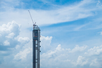 Obraz premium Construction site with crane on clear blue sky background. Building engineer safety concept. Copy space for text