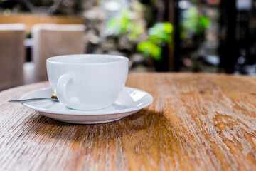 Front view of cup of coffee on brown wooden table at coffee shop. Hot espresso the best start to any morning at cafe with copy space.