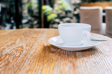 Cup of coffee on brown wooden table at coffee shop. Hot cappuccino the best start to any morning at cafe with copy space.