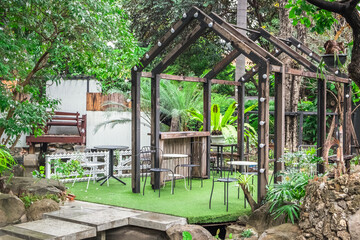 Fototapeta na wymiar Cozy outdoor cafe with table and chair at sunrise in the morning, Thailand. The atmosphere of the restaurant and the nature.