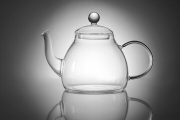 Transparent glass teapot on gray background