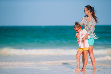 Fototapeta premium Beautiful mother and daughter at Caribbean beach enjoying summer vacation.