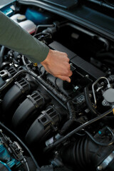 Fototapeta na wymiar Close up of man hand checking the engine of a broken car