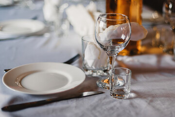 set of empty glasses and plates with Cutlery on a white tablecloth on the table in the restaurant