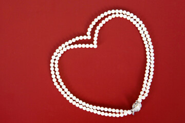 pearl necklace on red background