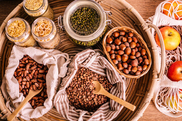 Variety of grains and legumes in glass jars and eco bags.
