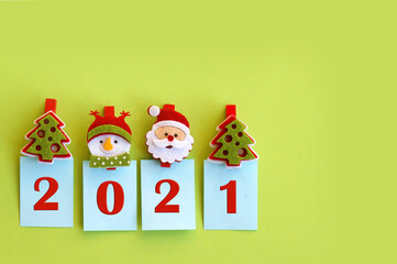 Year 2021 on a green background and symbols of the winter holiday.