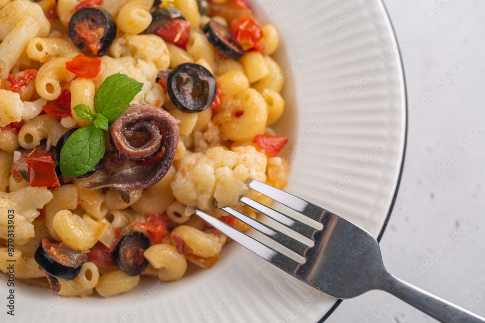 Poster Pasta with anchovy, cauliflower, olives and tomatoes, Close up. Top view.