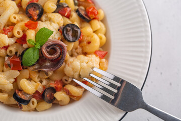 Pasta with anchovy, cauliflower, olives and tomatoes, Close up. Top view.