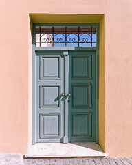 Painted wooden external door and colorful wall by the sidewalk, Athens, Greece