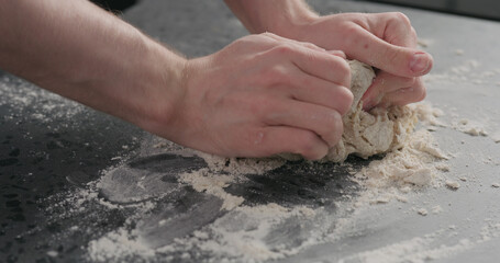 man working with dough on concrete countertop