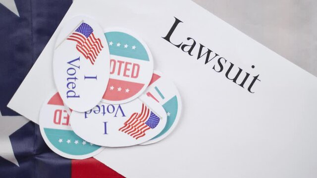 I voted stickers placing on Lawsuit paper with US flag as background - Concept of lawsuits in USA election