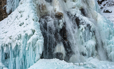 Fototapeta na wymiar Wasserfall im Winter: Wasser gefroren und flüssig