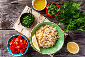 Top view of Middle eastern or arab dishes, set of ingredients of the classic Tabbouleh recipe, Traditional oriental salad Tabouleh