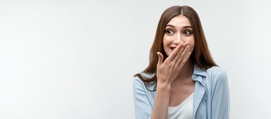 Charismatic girl in casual clothes covers her mouth with her hand.Copy space. Studio shot, white...