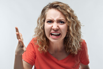 Angry blonde woman screaming and raising hand in anger. Negative emotion, facial expression concept