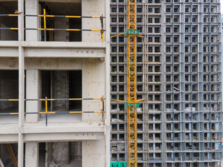 Drone aerial view of real estate building in construction house development concept. Crane tower in the construction site. Riverside office or apartment skyscrapers and the cityscape in background