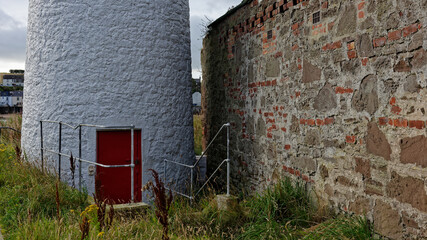 Fototapeta na wymiar The hidden entrance at the base of the Montrose Harbour rear Lighthouse, with its padlocked Maroon wooden door and railings at the steps leading down to it.