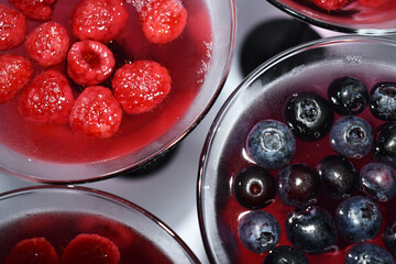 Blueberries and raspberries. Raspberry and blueberry jelly in glasses. Pink and blue background from berries. Berry sweet dessert.