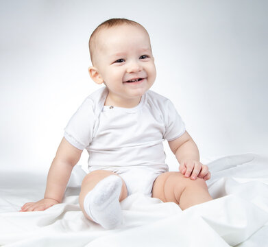Photo of sitting eleven-month-old baby on a white background