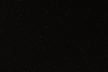 Black texture with micro-relief and glitter similar to the night sky with stars