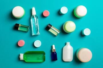 Obraz premium Group of plastic bodycare bottle Flat lay composition with cosmetic products on colored background empty space for you design. Set of White Cosmetic containers, top view with copy space