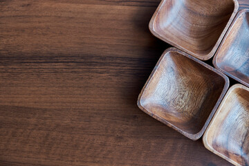 Wooden utensils for the kitchen, bowls, plates on a wooden table. The concept of natural dishes, a healthy lifestyle. Texture of wood. Wooden eco-ware. salad bowl on the brown wooden table background