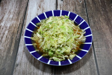 Traditional fried and stirred sliced Chinese cabbage seasoning with soy sauce and pepper on the plate. Famous vegetarian food menu in Asia. Low fat and diet concept. 
