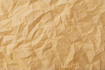 The texture of a crumpled yellow-gold disposable textile napkin.