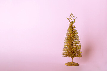 Christmas composition. Golden christmas tree decoration with glitters on pink pastel background. Mock up for new year gretting card. Close up, copy space for text or lettering