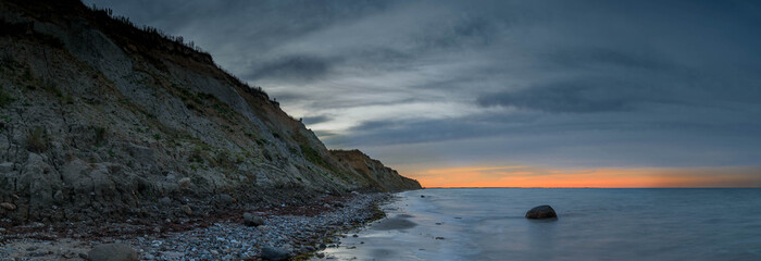 View of sunset on the steep coast of the Baltic Sea.Panorama view of wild romantic coastal cliff landscape at the Baltic Sea at the Stohl, Schwedeneck, Schleswig-Holstein, Germany