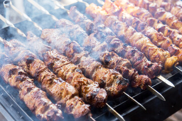 Marinated shashlik preparing on a barbecue grill over charcoal. Shashlik or Shish kebab popular in Eastern Europe. Shashlyk (skewered meat) was originally made of lamb. Roast Beef Kebabs On BBQ Grill.