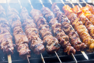 Marinated shashlik preparing on a barbecue grill over charcoal. Shashlik or Shish kebab popular in Eastern Europe. Shashlyk (skewered meat) was originally made of lamb. Roast Beef Kebabs On BBQ Grill.