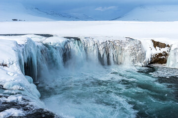 Scenic winter view of Godafoss waterfall in Iceland. Picturesque winter landscape with frozen waterfall in Iceland.