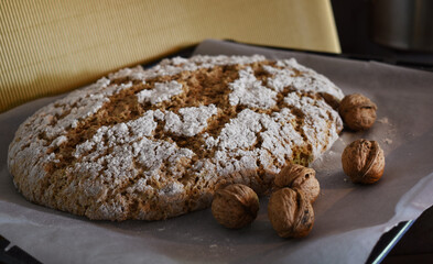 Brot backen mit Nüssen, Nussbrot vor goldenem Hintergrund mit Mehl und weihnachtlichen Farben