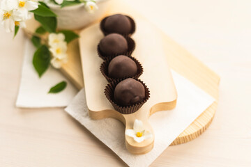 Handmade chocolates on a light wooden background. Chocolate balls raw