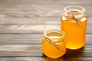Jar of honey on grey wooden table.